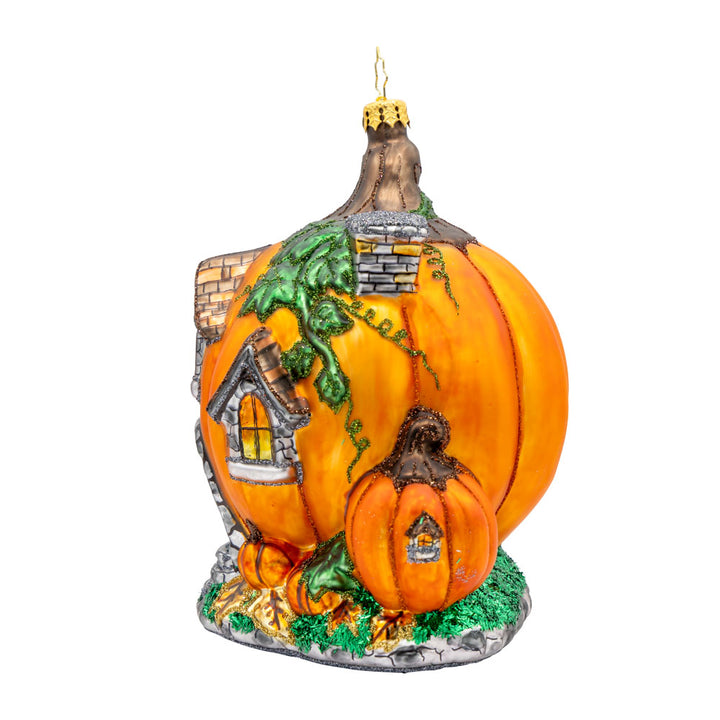 Pumpkin Patch Abode Ornament. Featuring a vibrant pumpkin exterior with windows, a whimsical door, and a leafy roof. View of right side.