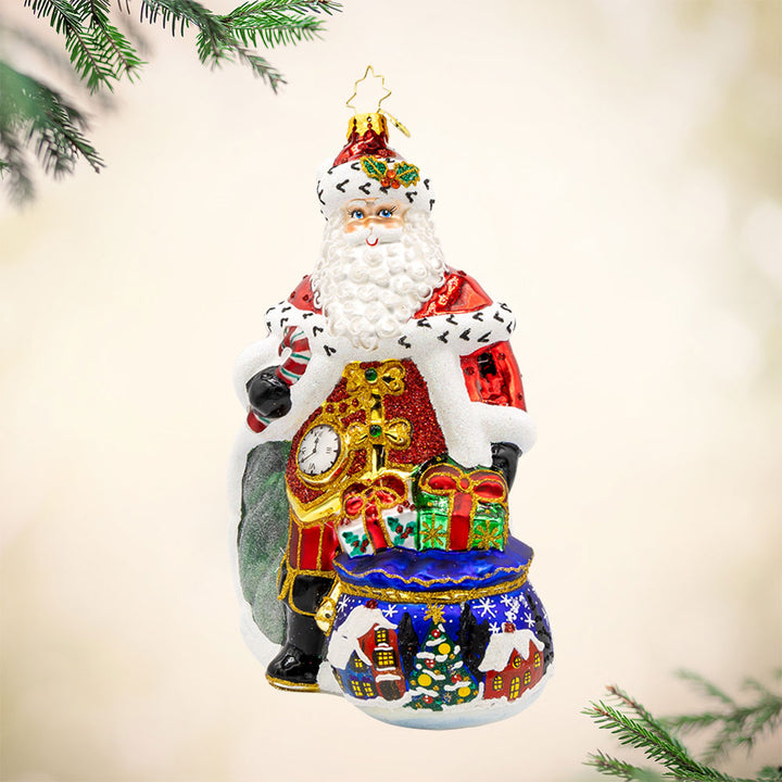 A Regal Christmas ornament. Santa is dressed in a royal red robe and festive cape. With a shiny staff and touch of glitter everywhere. View of front.