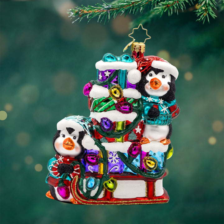 Flurry Friends Sleigh Ride ornament. Penguin pals on a holiday sleigh ride to deliver presents. View of front. 