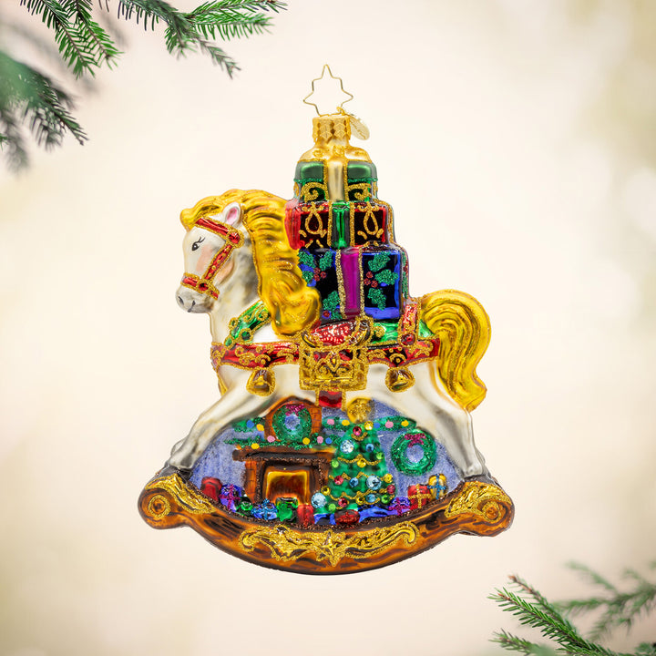 Rockin' Around Christmas ornament. Charming rocking horse with gifts stacked on its back. Hand-painted with a festive Christmas scene. View of right side.
