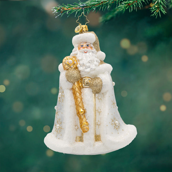 Gilded Kris Kringle ornament. Dressed in a shimmering robe, adorned with sparkling jewels and a regal crown. His festive cape and shimmering staff complete this elegant ensemble. View of front. 