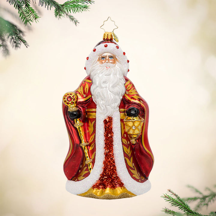 Crimson Noel Santa ornament. With his sparkling red cape, shiny scepter, and gold-detailed gown. View of front.