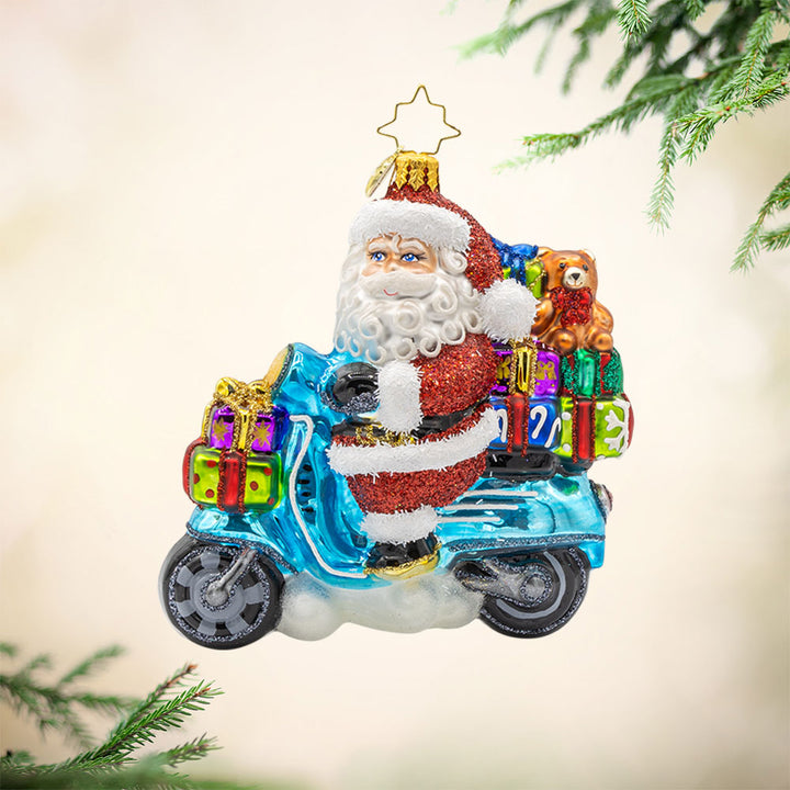 Vroom Vroom Voyage ornament. Santa is ditching the sleigh for a shiny Vespa full of gifts. View of front.