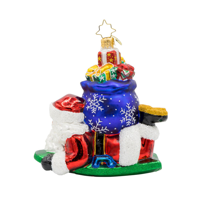 Snowy Sleigher ornament. Dressed in his red suit, Santa is perched on his sled, with a gift sack of presents on his back. View of back.