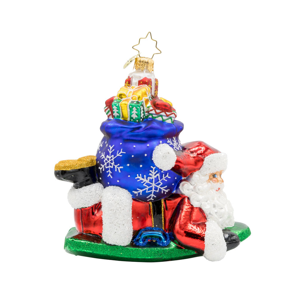 Snowy Sleigher ornament. Dressed in his red suit, Santa is perched on his sled, with a gift sack of presents on his back. View of front. 