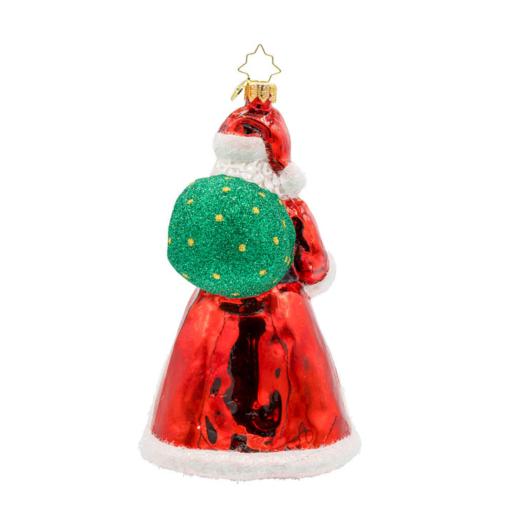 St. Nick's Winter Wonderland ornament. Santa stands amidst a picturesque snowy village. The hand-painted scene features twinkling lights and cozy homes surrounding a Christmas tree in the center. View of back.