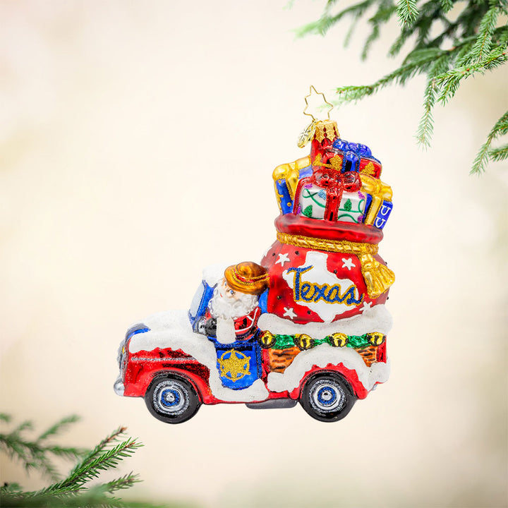 Lone Star Santa Cruiser ornament. Santa's driving a car with a Texas gift bag in tow. View of front.