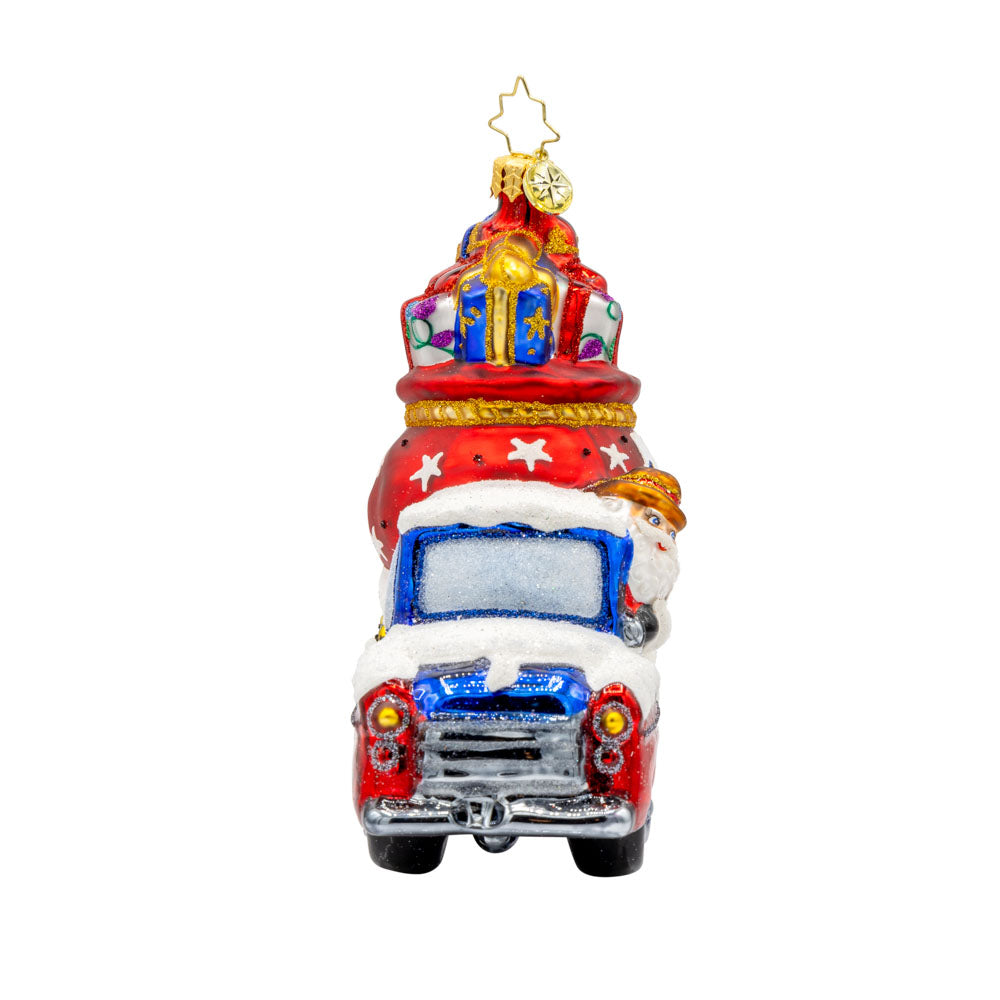 Lone Star Santa Cruiser ornament. Santa's driving a car with a Texas gift bag in tow. View of left side.