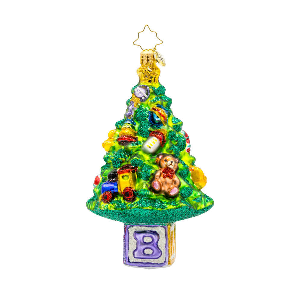 Bundle of Joy Spruce ornament. This piece features a decorated Christmas tree and a collection of baby-themed toys. View of back.