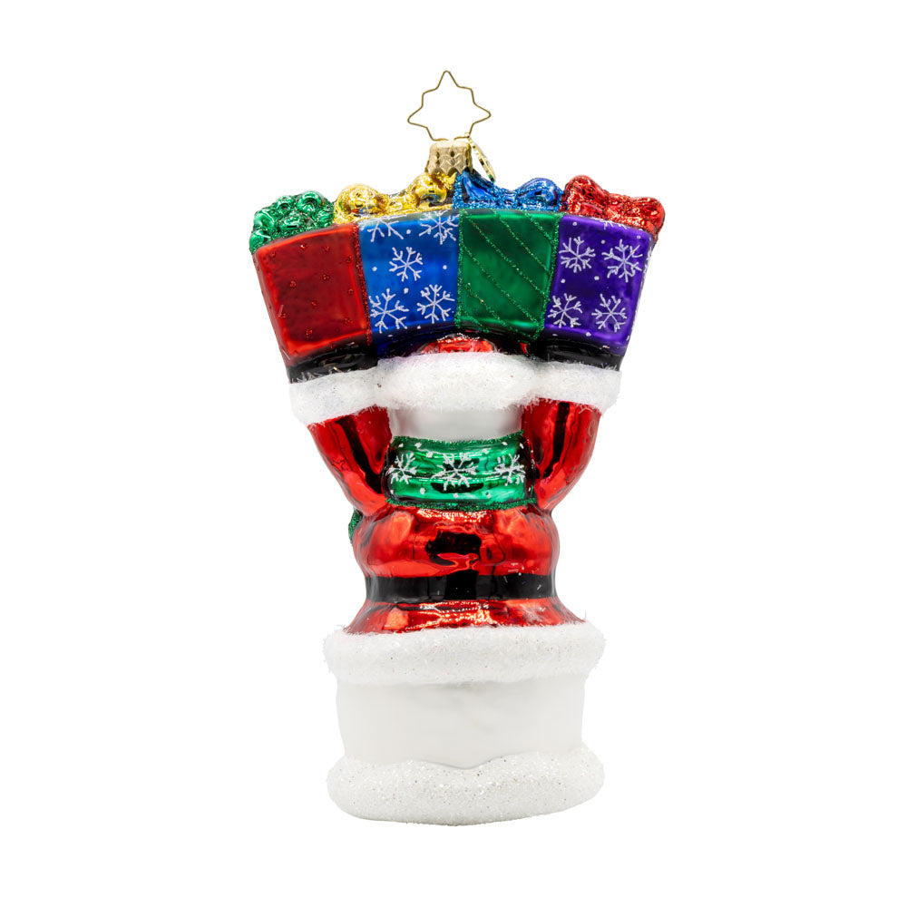 2025 Snowman Greetings ornament. A snowman dressed as Santa raises a stack of gifts dated "2025" above his head. View of back.
