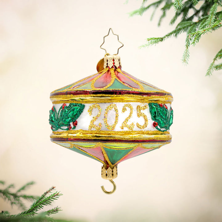 Remembering The Year 2025 ornament. Festive shades of green and red, sprigs of holly, and dated "2025." View of front. 