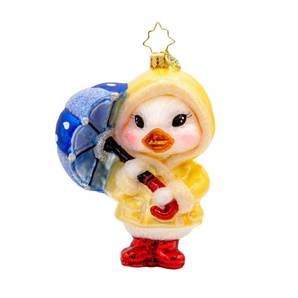 Rainy Day Duckling ornament. Dressed in a tiny, vibrant raincoat and rain boots, blue umbrella in tow. View of front.