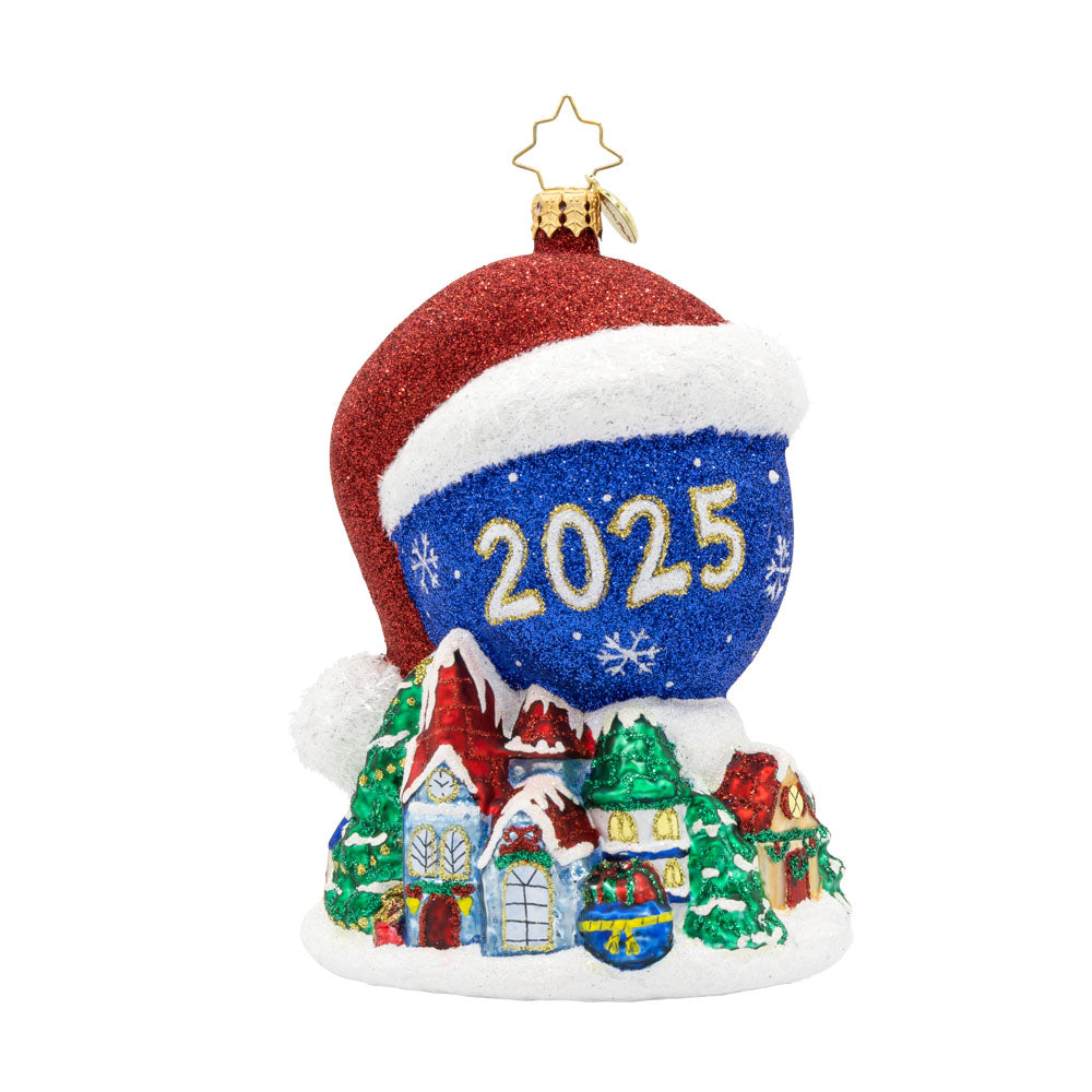 Twas the Night Before Moonlight ornament. Dressed in a Santa hat, this glowing moon dated with "2025" keeps a watchful eye on the Christmas village below. View of front.