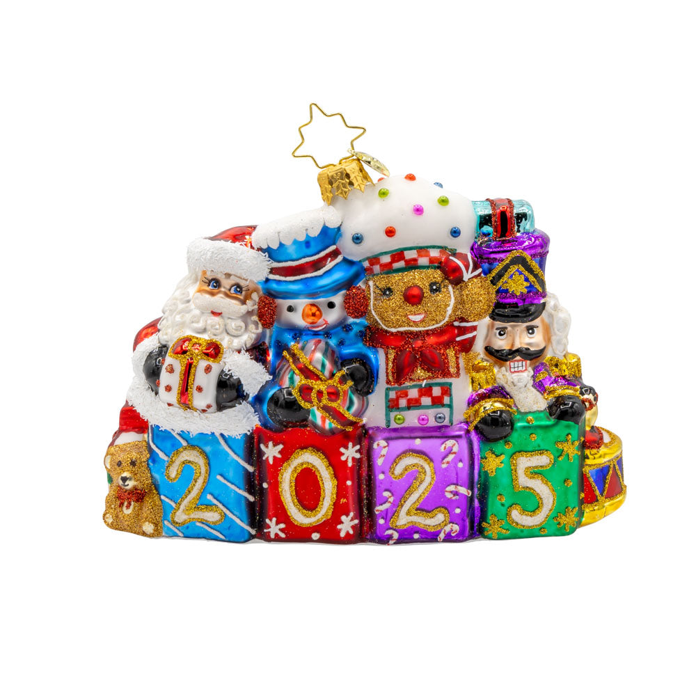 Stacking Up The Cheer ornament. A row of gifts dated with "2025." Behind them sits a snowman, gingerbread man, nutcracker and drummer boy. View of front. 