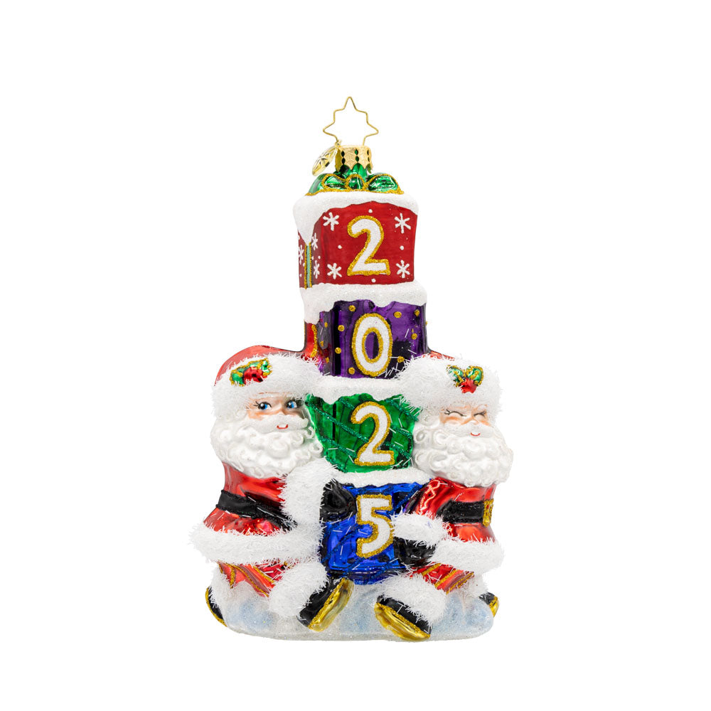 Gift Giving Santa's 2025 ornament. Two Santa's carry a stack of gifts with "2025" written on them. View of front. 