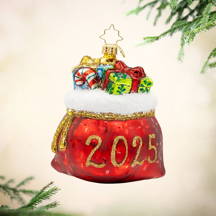 Yearly Yuletide Tote ornament. The gift bag is filled with festive presents, dated "2025." View of front. 