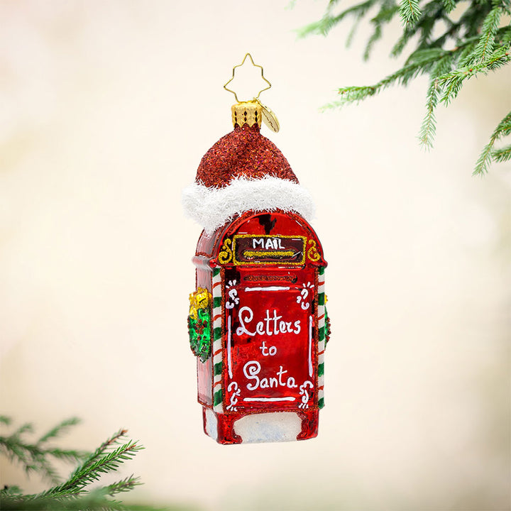 North Pole Postbox ornament. A festively decorated red postbox with "Letters to Santa" written on it. Topped with Santa's red hat. View of front. 