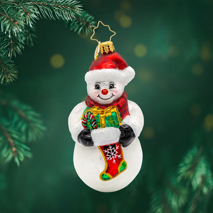 Holiday Stocking Joy ornament. This snowman is holding a stocking filled with holiday goodies. View of front. 