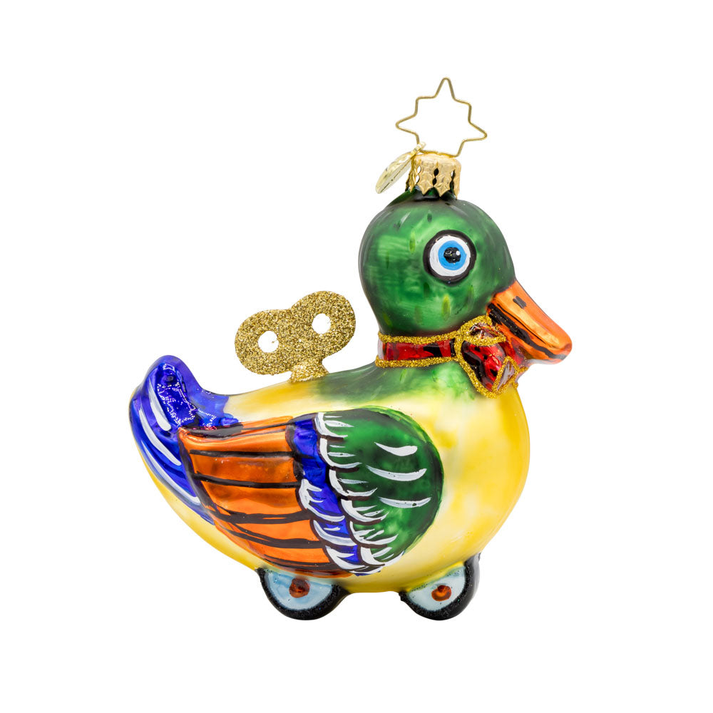 Dapper Duckling ornament. This wind-up duck dons' shiny green feathers, sparkling eyes, and a dapper red bow. View of front. 