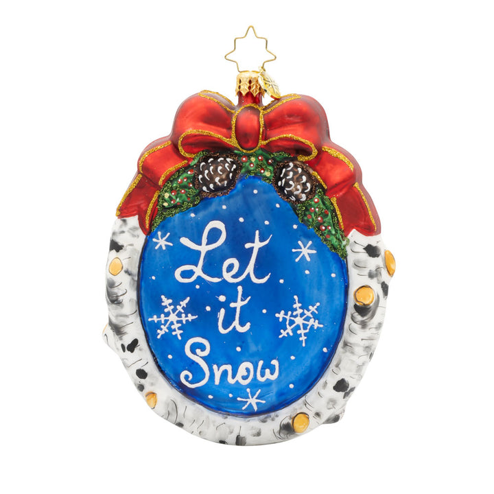 Winter Wonderland Wanderer ornament. Santa and his furry friends explore a snowy wonderland. This scene is framed by a wreath. "Let it Snow" is written on the back. View of back.