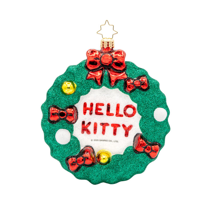 Hello Kitty's Holiday Wreath ornament. Hello Kitty wears her signature red bow nestled in a festive wreath adorned with red bows, holly, and sparkly accents. View of back.