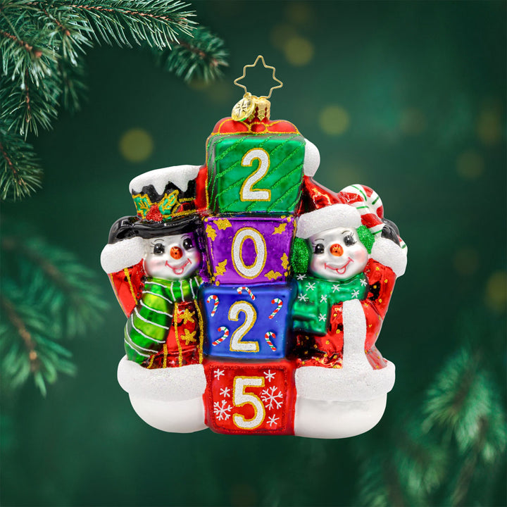 2025 Snowy Stackers ornament. These two snowmen are stacking up presents like building blocks. The gifts are dated with "2025." View of front.