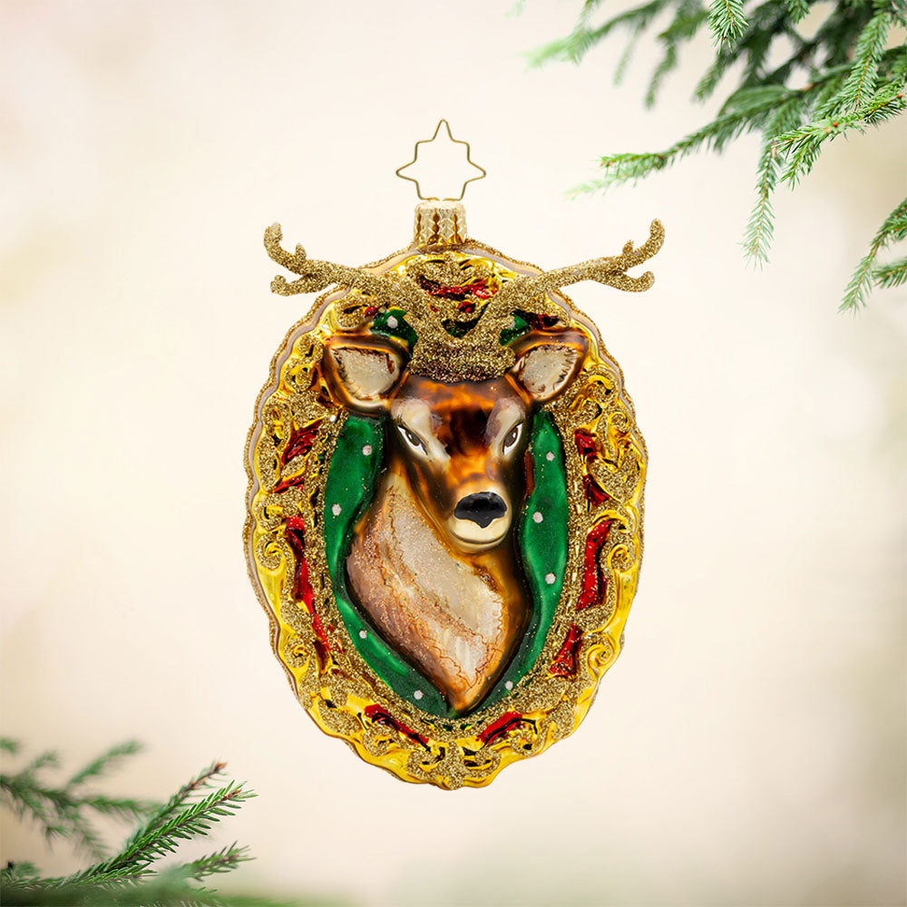 Mantle Majesty ornament. This deer and his shimmering antlers are centered within a golden frame. View of front.