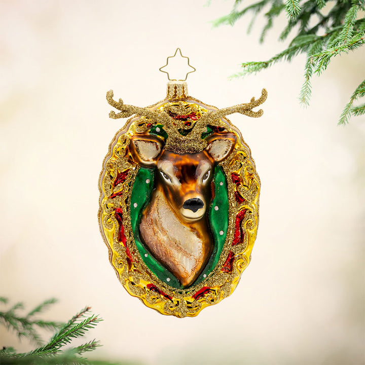 Mantle Majesty ornament. This deer and his shimmering antlers are centered within a golden frame. View of front.