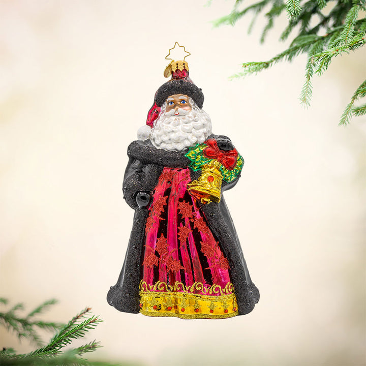 Bells of Christmas Santa ornament. Santa and his festive bell, dressed in a rich dark red gown with a shimmering pattern. View of front.