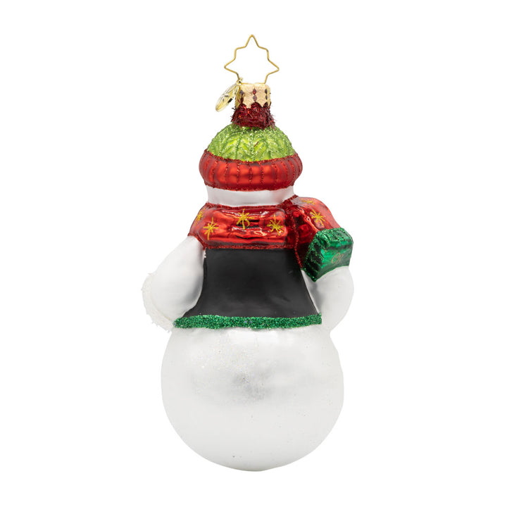 Festive Folk Flair ornament. Dressed in a cozy vest with hand-painted folk-art designs and a cheerful pom-pom hat. His glittering gloves and shining scarf bring the sparkle, while a Christmas tree adorned with stars and berries completes his festive look. View of back.