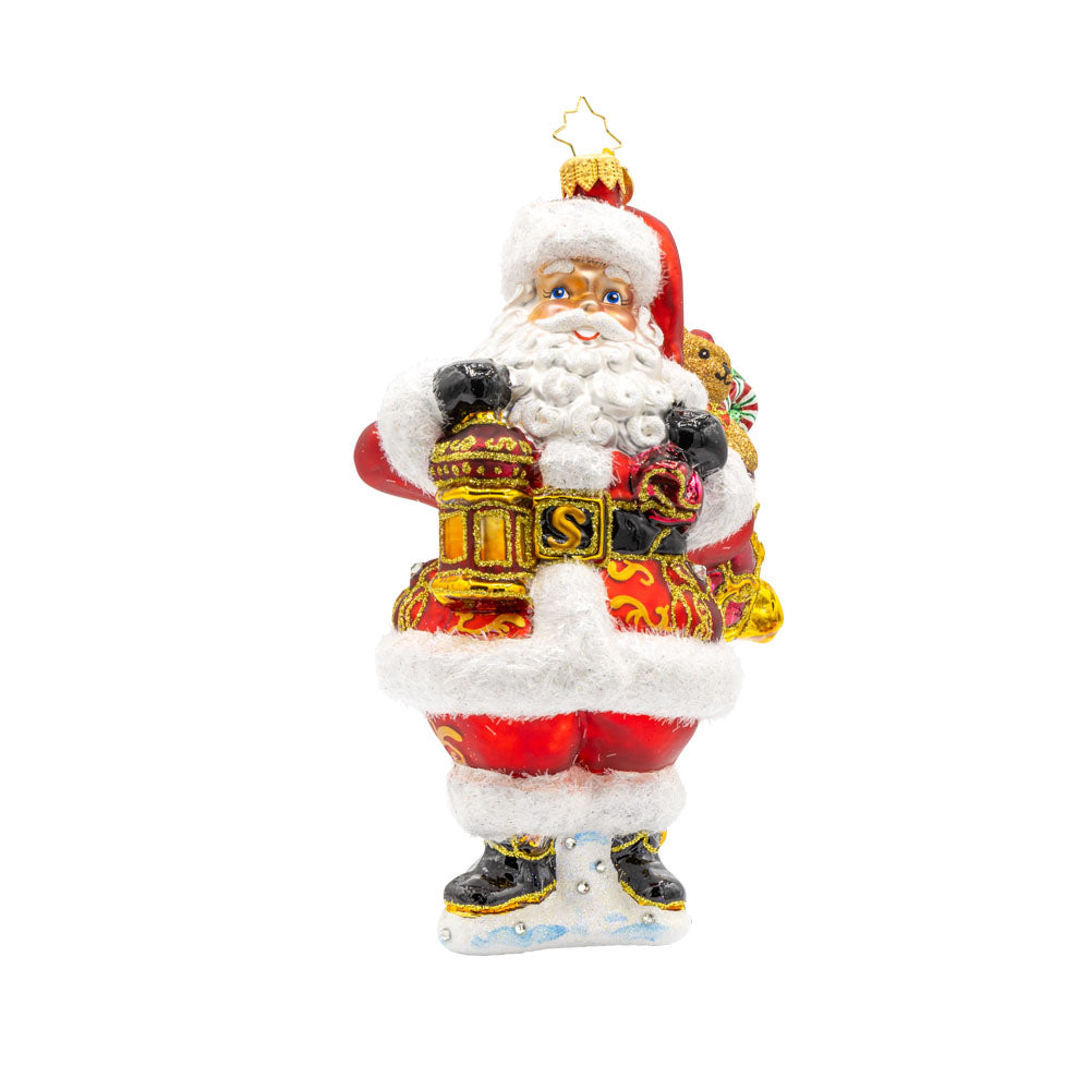 A Clause to Celebrate ornament. With his festive lantern, sparkling eyes, and a cuddly teddy bear by his side. He's dressed in his traditional red suit and hat. View of front. 
