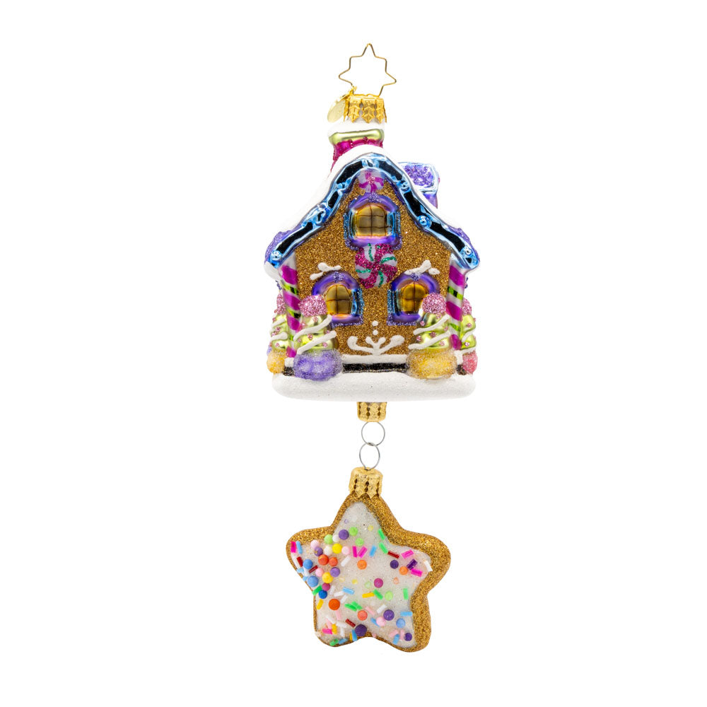 Sweet Beginnings ornament. A gingerbread house decorated in vibrant colors and candy. A gingerbread star cookie covered in sprinkles hangs below. View of back.