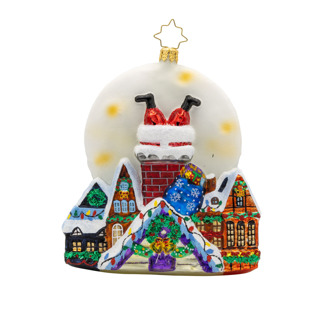 Santa's Moonlight Mischief ornament. Santa goes headfirst down a chimney a set a scene of festive homes lit by a large moon. View of front. 
