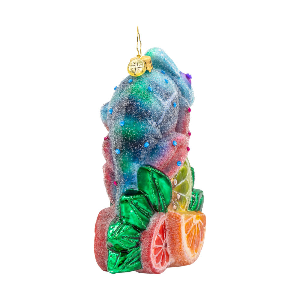 Camouflage Cutie ornament. A chameleon is perched on a vibrant pile of fruit. View of back.
