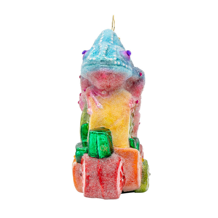 Camouflage Cutie ornament. A chameleon is perched on a vibrant pile of fruit. View of front.