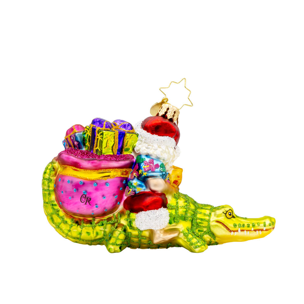 Sunshine State Gator ornament. Santa is trading in his sleigh for a gator and enjoying a tropical cocktail. "Florida" is written on gift sack. View of back.