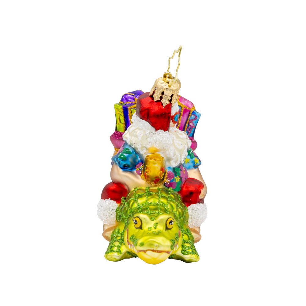Sunshine State Gator ornament. Santa is trading in his sleigh for a gator and enjoying a tropical cocktail. "Florida" is written on gift sack. View of left side. 