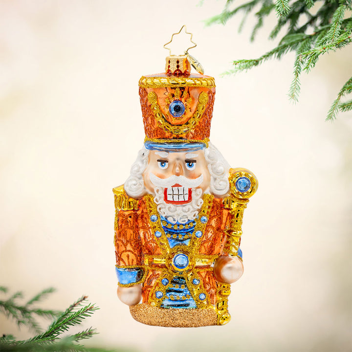 Gilded Guardian ornament. This nutcracker is donned in all gold with blue accents. View of front. 