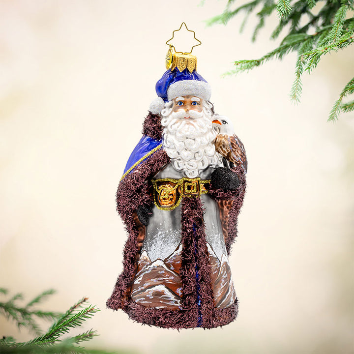 Mountain Majesty St. Nick ornament.  Santa’s dons a hand-painted mountain-scene coat with an eagle by his side. View of front. 