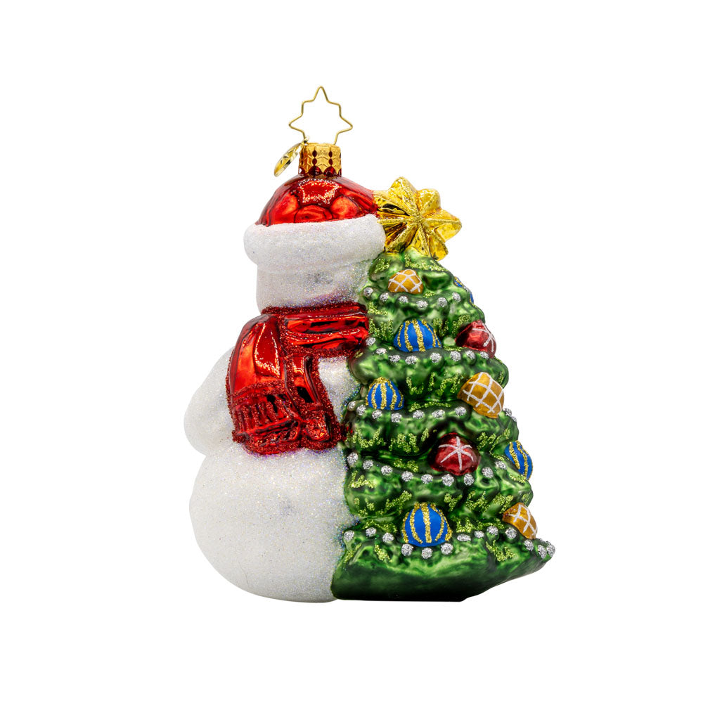 Snowy & Bright ornament. This snowman dons a red Santa hat, bearing a gift in hand. He leans against a decorated Christmas tree. View of back.