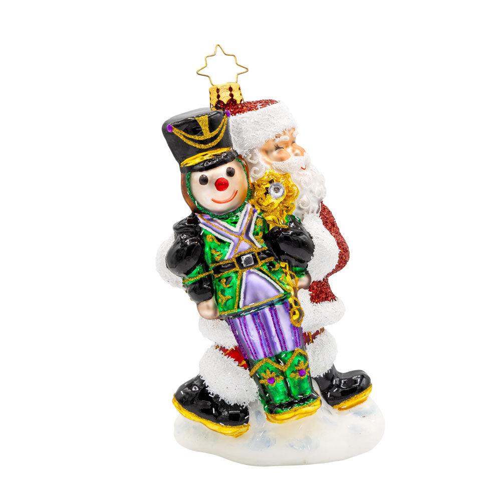 The Christmas Guardian ornament. Santa has a life-size nutcracker in vibrant colors of green, black, purples, and gold. View of front. 