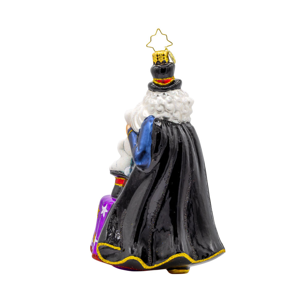 The Merry Magician ornament. Santa features a fluffy beard and cape as he pulls a rabbit out of his sparkling hat. View of back.
