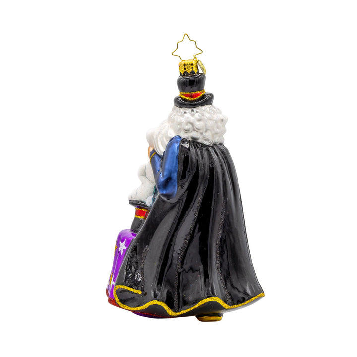 The Merry Magician ornament. Santa features a fluffy beard and cape as he pulls a rabbit out of his sparkling hat. View of back.