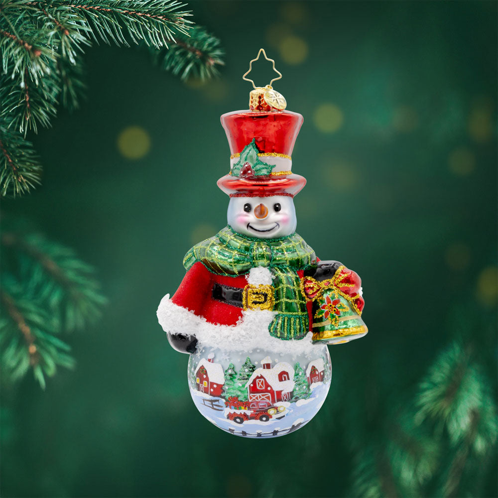 Snowy Sentinel ornament. From his shiny hat and pulled nose to his cozy scarf and festive bell. The hand-painted scene adds a touch of winter magic to this delightful ornament. View of front.