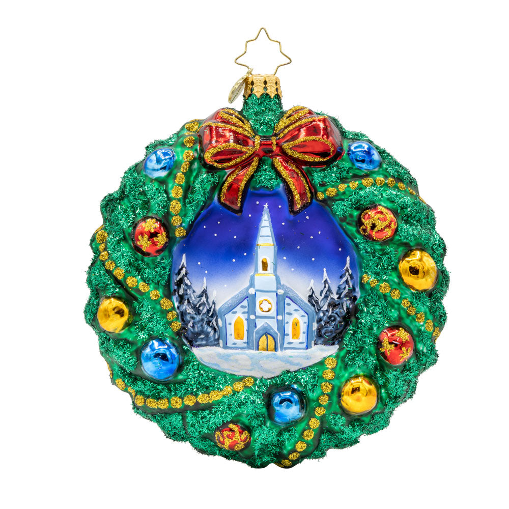 Sacred Harmony Wreath ornament. An elegantly designed wreath, showcasing a charming church in the center. View of front. 