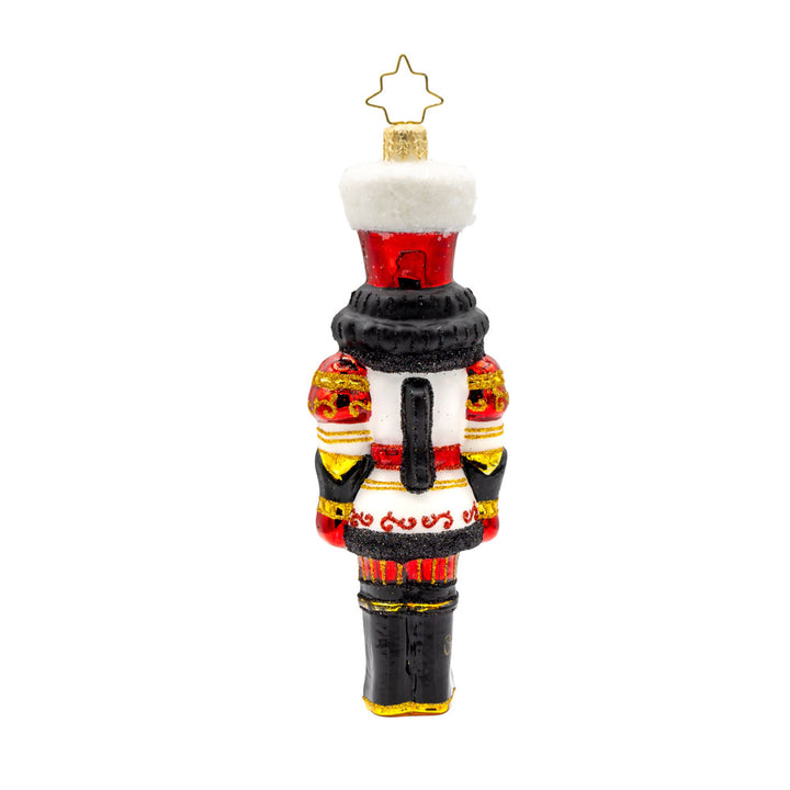 Gemstone Guardian ornament. This nutcracker wears a satin white jacket adorned with red gems and shiny black boots. View of back.