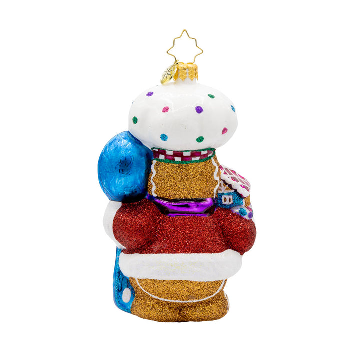 Spoonful of Sweetness ornament. This gingerbread man is wearing a festive chef's outfit, spoon in hand, and gingerbread house in the other. View of back.