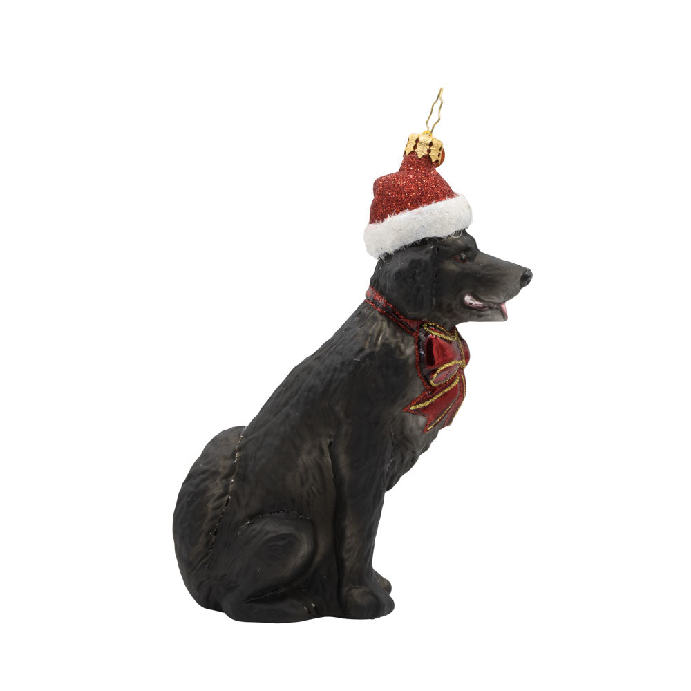 Loyal Lab ornament. A black dog with a Santa hat perched atop their head. View of left side.