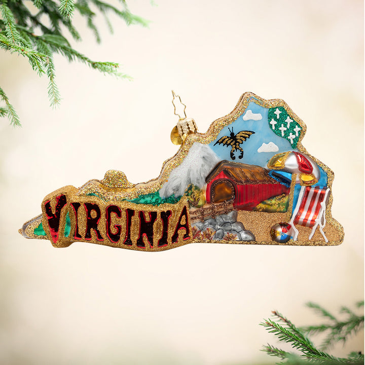 A Virginia View. Ornament of mountains to sandy shores with the phrase "Virginia" with a cozy red barn, a butterfly, a beach chair, an umbrella, and beach ball. View of front