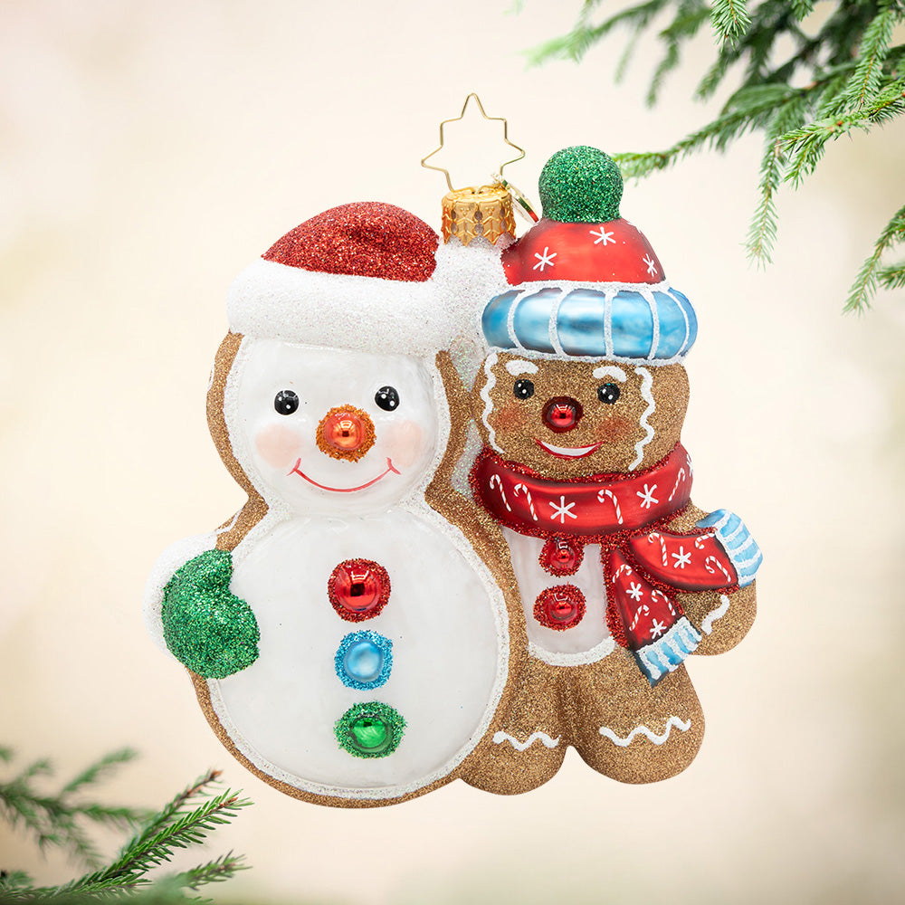 Deck the Dough. Ornament of a gingerbread man, in a red and blue matching scarf and hat, next to a giant snowman cookie. View of front